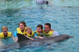 Family in dolphin pool